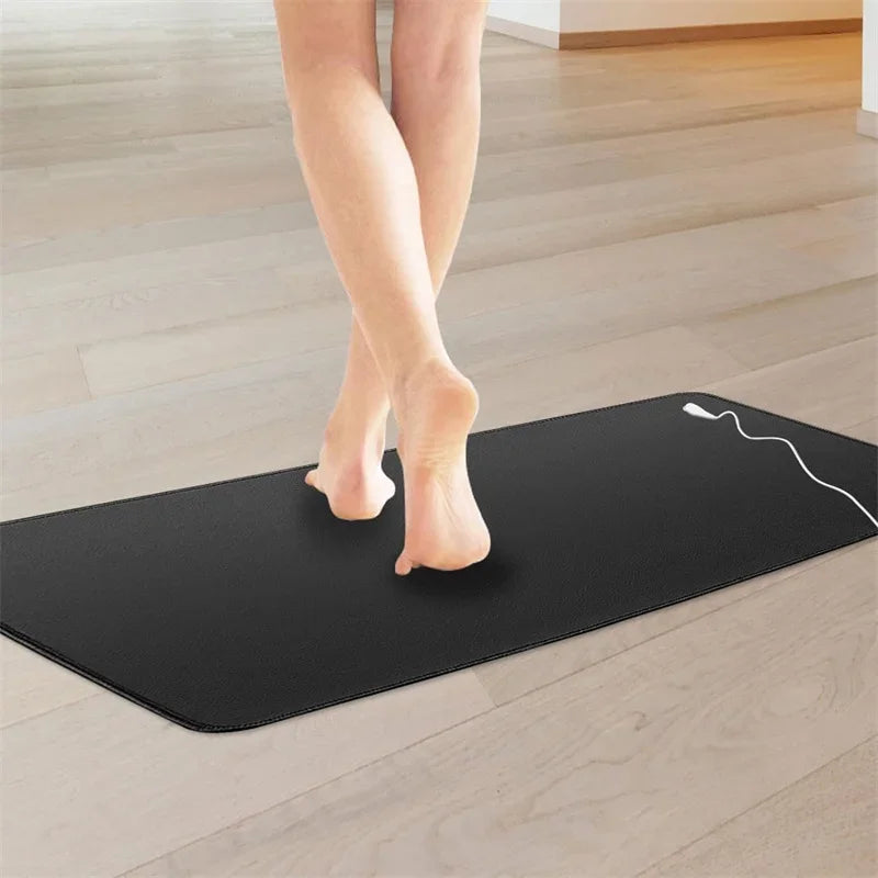 Bare feet on the grounding mat on a wooden floor